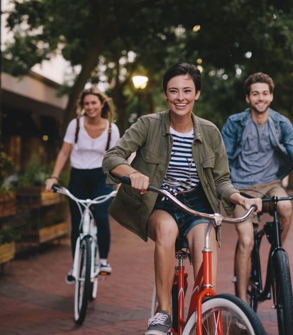 a group of young people riding bikes down a street
