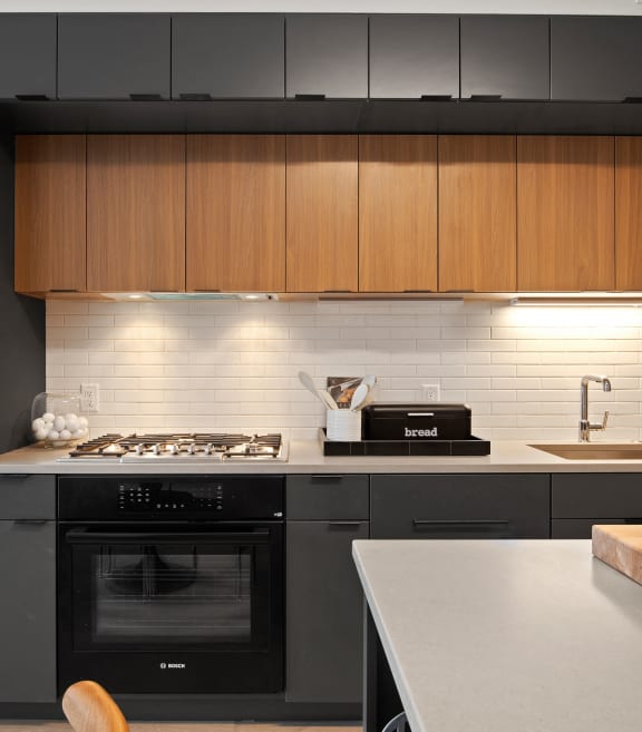 a kitchen with wooden cabinets and high-end appliances at Tribeca NOMA apartments