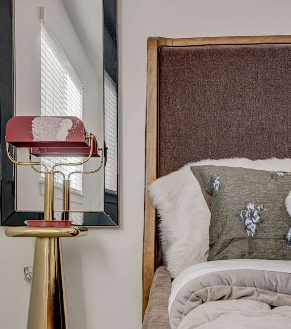 A bed with pillows and a side table with a lamp at Mt. Rainier houses for rent in Herriman, Utah.