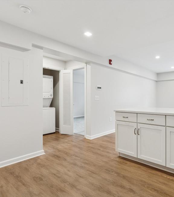 A kitchen with white cabinets and a window at Roosevelt Commons Apartments, Pennsylvania