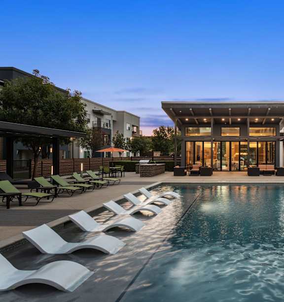 A modern house with a pool in front.