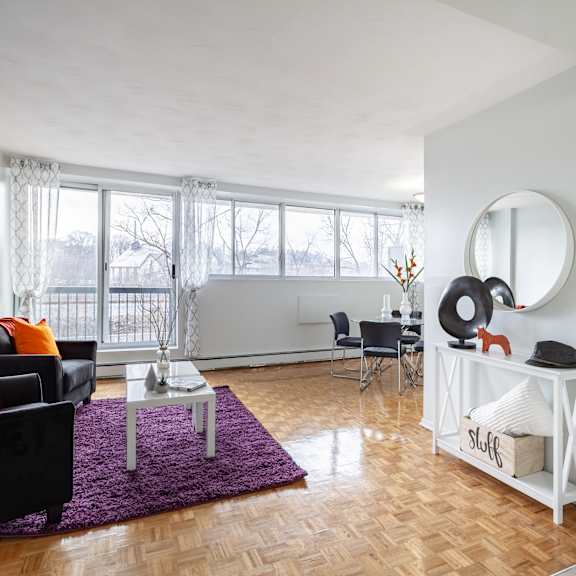 A living room with a grey couch, a round table, and a television.