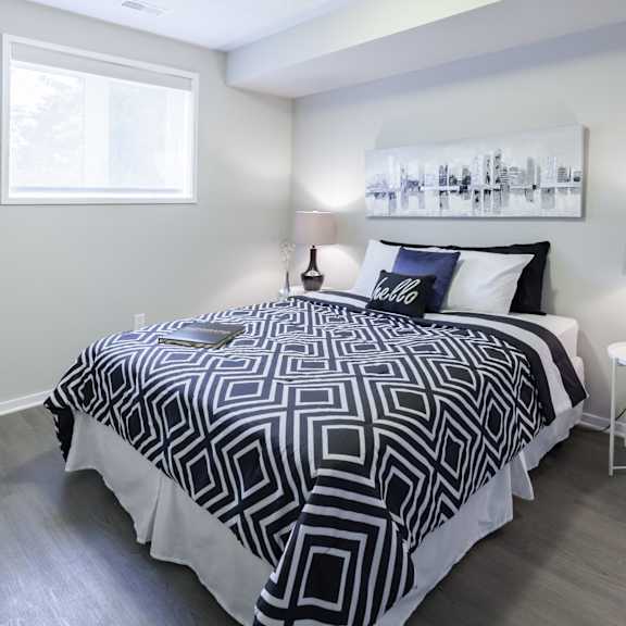 A bedroom with a large bed and a painting on the wall.
