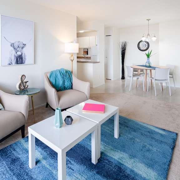 A living room with a grey couch, a round table, and a television.