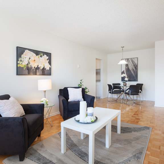 A living room with a grey couch, a round table, and a television.
