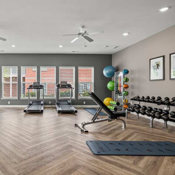 A spacious gym with a variety of equipment and a large mirror on the wall.