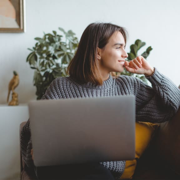 a woman sitting on a couch with a laptop