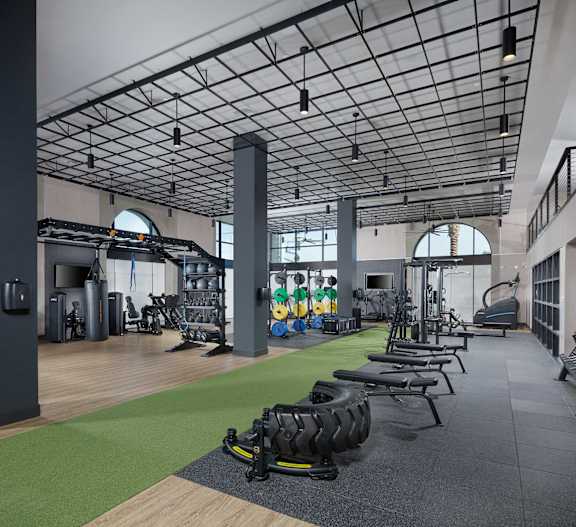 A gym with a variety of equipment including treadmills, weights, and exercise machines.