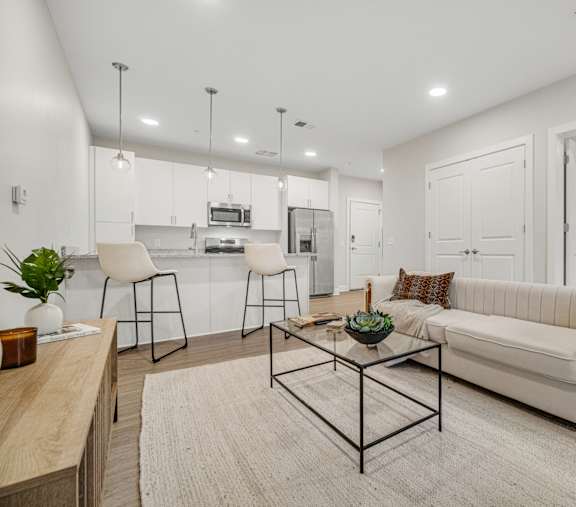 A modern living room with a white couch and a coffee table in the center.at Park Lamont Apartments & Townhomes, Ohio