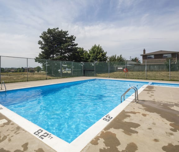 a swimming pool at a condominium with a fence around it