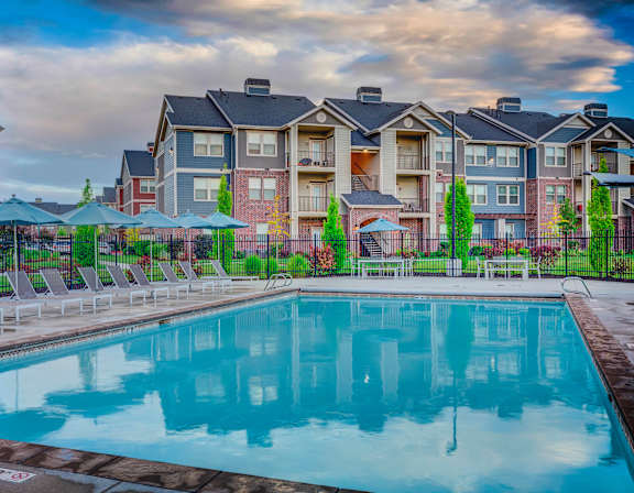A swimming pool in front of apartment buildings.