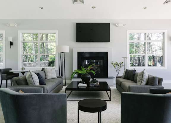 A modern living room with a fireplace and a television mounted above it.