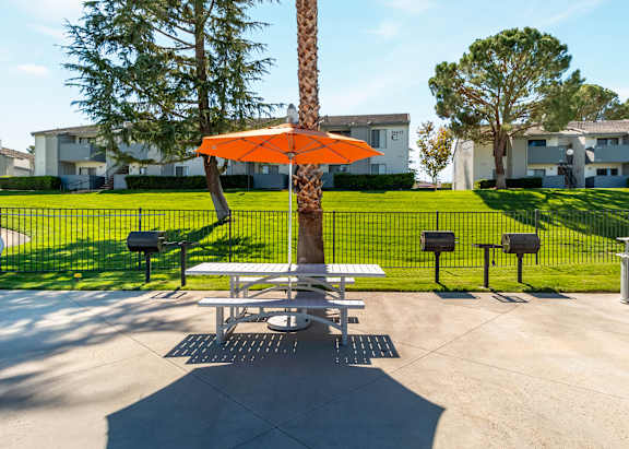 The Chaparral Apartment complex is located in a grassy area with trees at Chaparral Apartments , California 93551