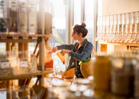 A woman is shopping in a store with a variety of items on display.