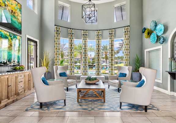 A living room with a large window and a view of a pool.