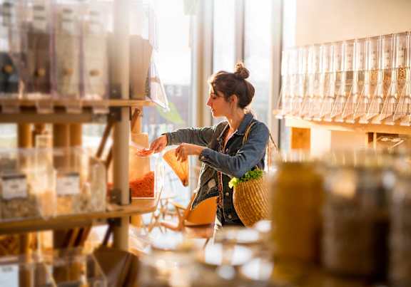 A woman is shopping in a store with a variety of items on display.