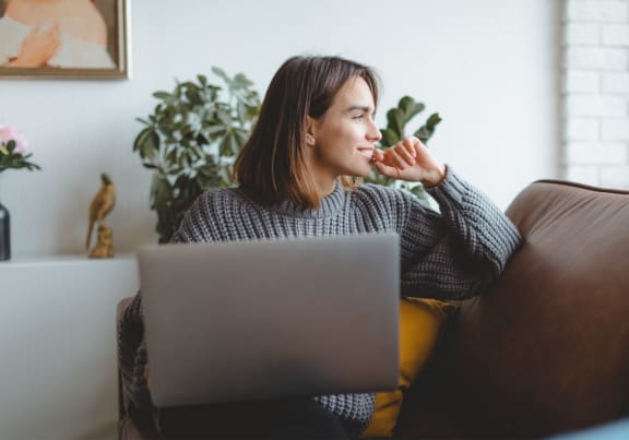 a woman sitting on a couch with a laptop