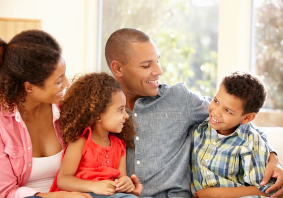 a family sitting on a couch with their children