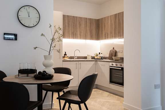 a small kitchen with a table and a clock on the wall
