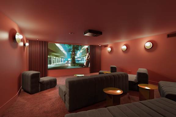 a screening room with couches and chairs and a projection screen