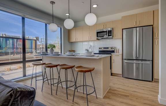 A kitchen with a bar area and a refrigerator.