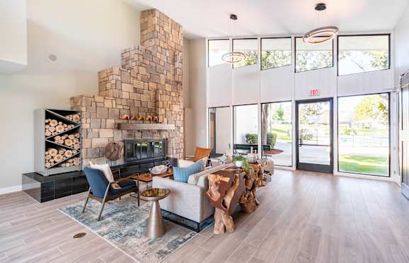 A living room with a fireplace and a couch at Chaparral Apartments , California 93551