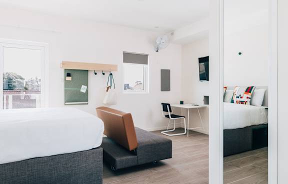 a living room with a green couch and a balcony