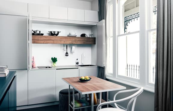 a living room with a green couch and a balcony