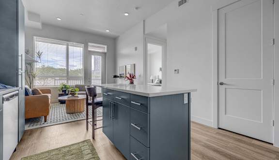 Kitchen open concept floor plan that leads into the living room with a patio door at our modern apartments in Salt Lake City.