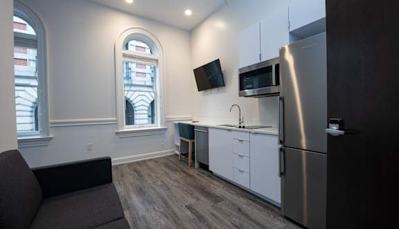 A kitchen with a refrigerator, microwave, and oven.