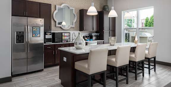 A modern kitchen with a large island and chairs.