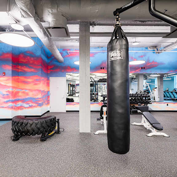 A gym with a punching bag hanging from the ceiling.