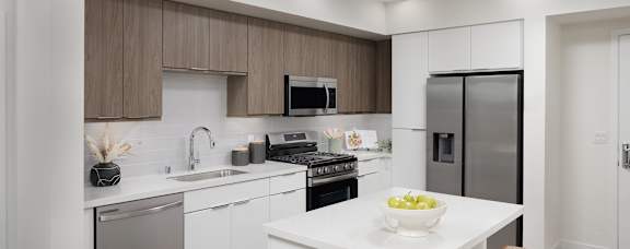 A modern kitchen with wooden cabinets and stainless steel appliances.