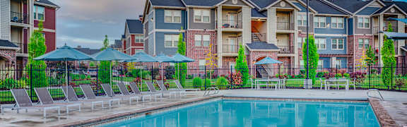 A swimming pool in front of apartment buildings.