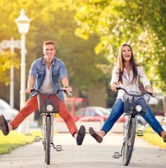 Two people are riding bicycles and appear to be in mid-air. at Woodlands Creekside Apartments, McDonough, GA, 30253