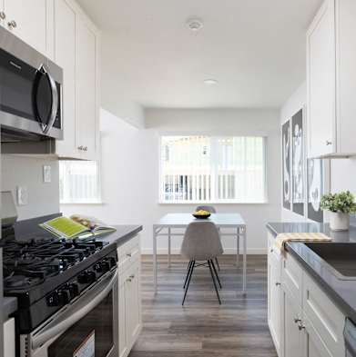 A modern kitchen with a stove, sink, and a dining table with chairs at Santa Rosa Oaks, Santa Rosa, 95401