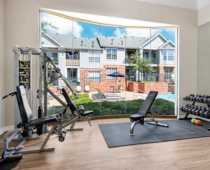 A gym with a view of a brick building across the street.