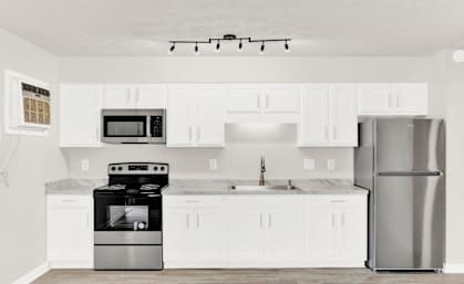 a white kitchen with stainless steel appliances and white cabinets