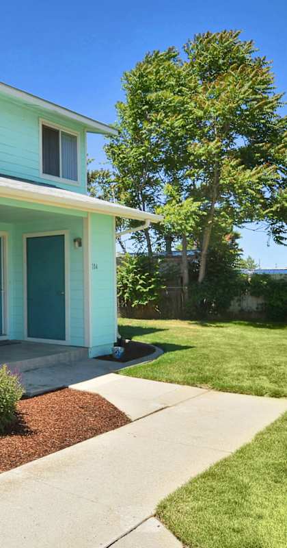 a blue house with a sidewalk in front of it