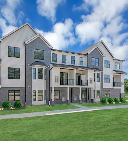 A modern two-story residential building with a well-manicured lawn in front. at The Franklin Marlboro Apartments, Marlboro, NJ 07746