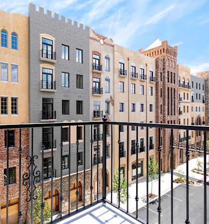 a balcony with a black railing and a view of a brick building