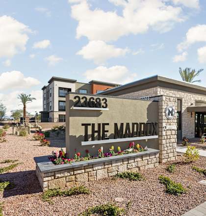 The Maddox sign is in front of a building with a clear blue sky in the background.