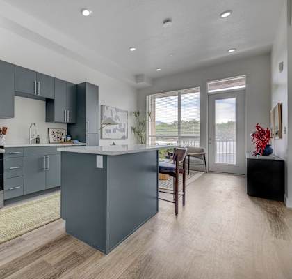 A modern kitchen with a refrigerator, oven, and microwave.