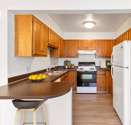 A kitchen with wooden cabinets and a white refrigerator.
