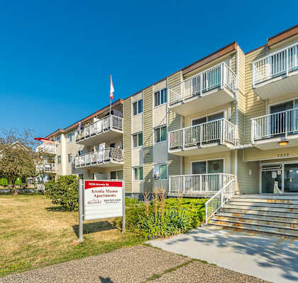 Apartment building with a sign in front that says "Apartments for sale".