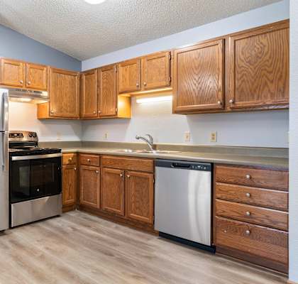 A kitchen with wooden cabinets and stainless steel appliances.