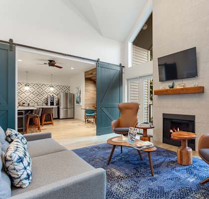 A living room with a grey couch, a brown chair, and a fireplace.