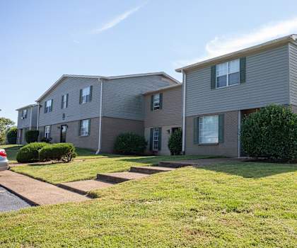 an apartment building with a yard in front of it