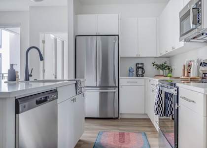 A modern kitchen with white cabinets and stainless steel appliances.