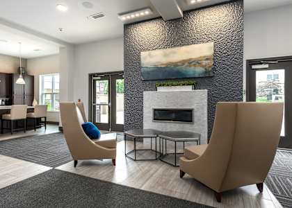 A modern living room with a fireplace and two chairs.